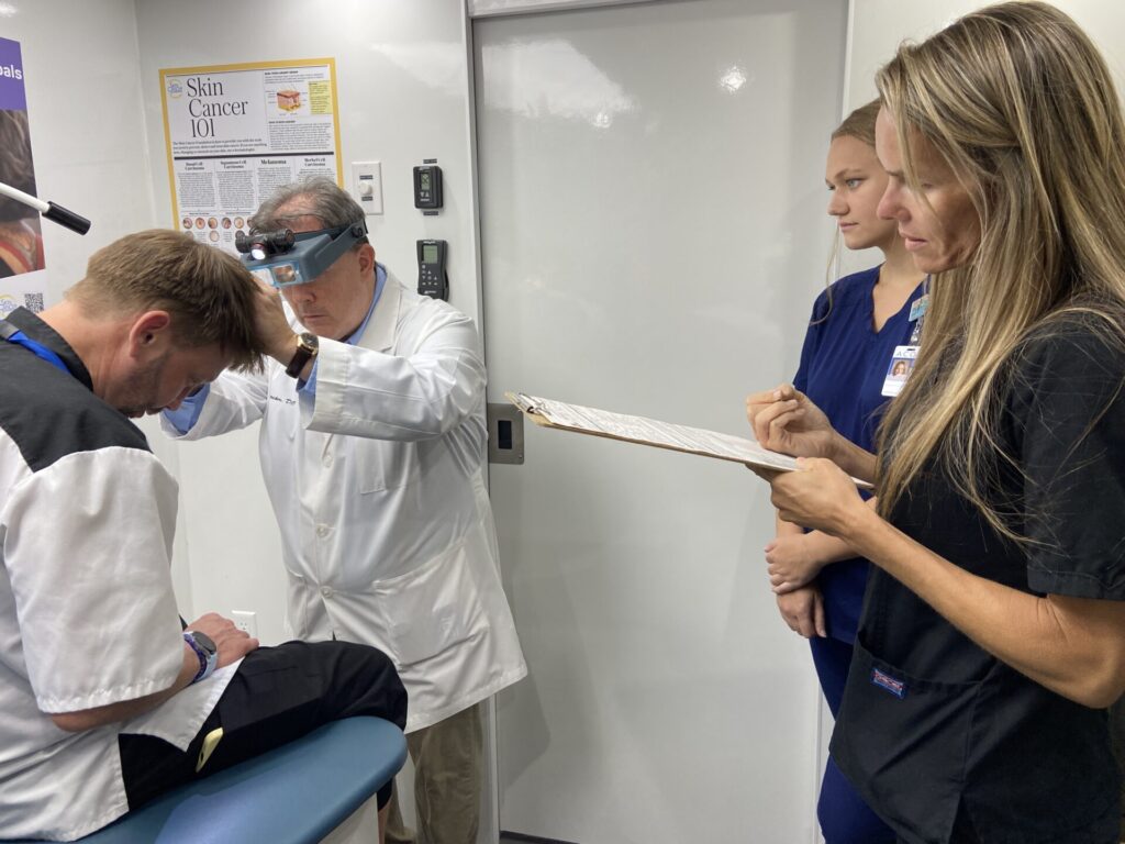 Der ehrenamtliche Dermatologe Dr. Jeff Stricker führt in Dothan, Alabama, eine Hautuntersuchung von Kopf bis Fuß durch.