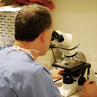 Mohs-Chirurg untersucht Tumor